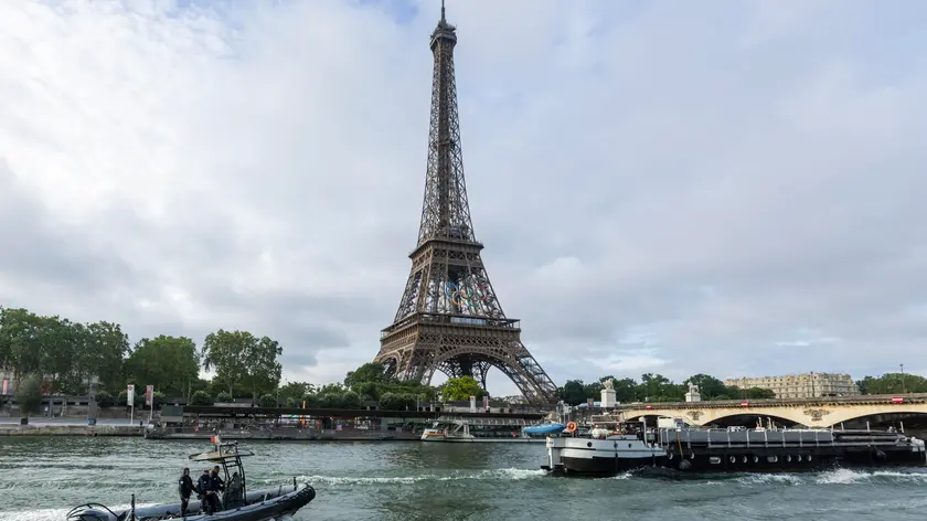 epaselect epa11417308 Sightseeing boats and a police rubber dinghy sail on the Seine river near the landmak Eiffel tower during a rehearsal for the Opening Ceremony of the 2024 Paris Olympic Games, in Paris, France, 17 June 2024. The Olympic Games in the French capital will take place from 26 July to 11 August 2024. EPA/ANDRE PAIN