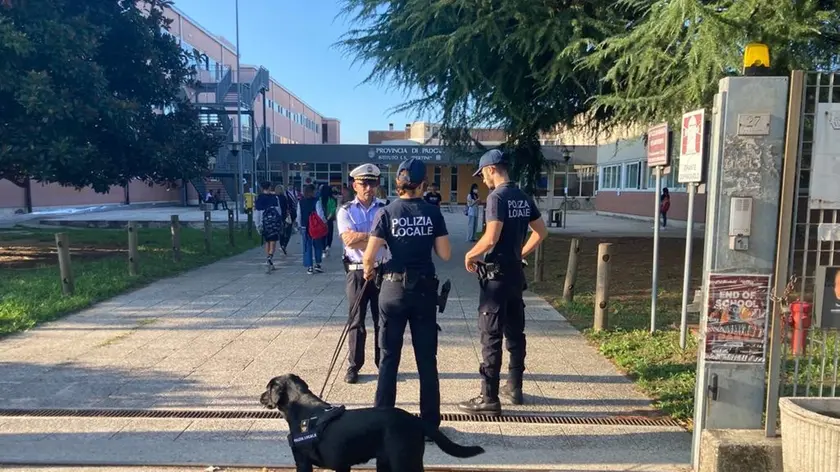 Controlli della polizia locale con l'unità cinofila fuori da una scuola