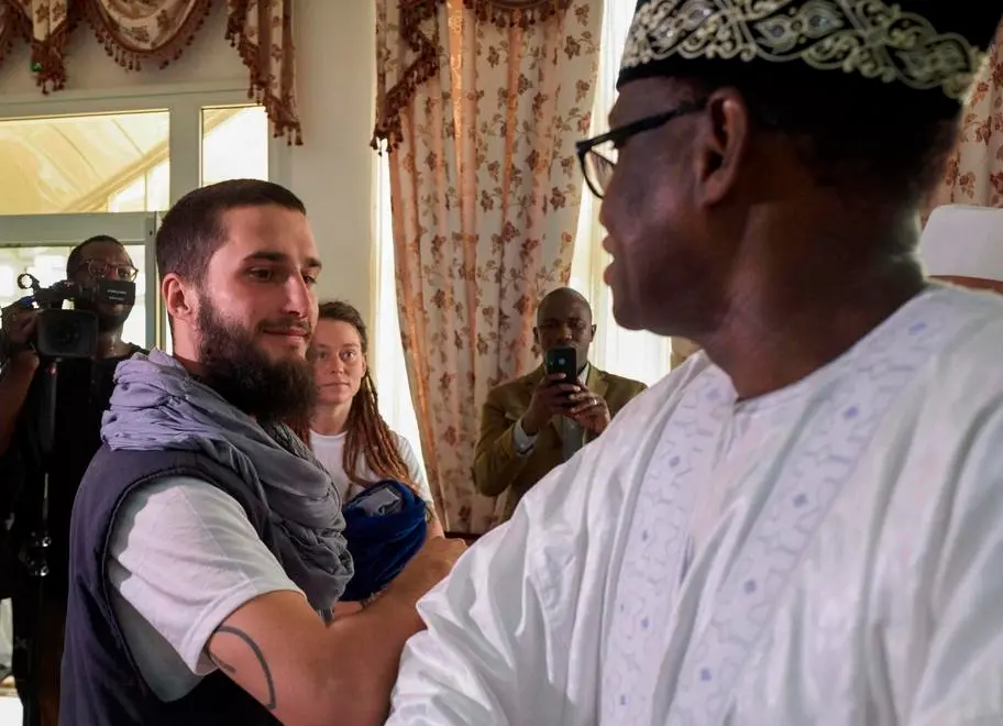 Italian Luca Tacchetto (C) and Canadian Edith Blais (C/R) are greeted by officials as they arrive at the airport in Bamako on March 14, 2020, after their release by UN peacekeepers. - A Canadian woman and her Italian partner kidnapped in Burkina Faso in 2018 have been found alive in the northwest of Mali by UN peacekeepers, diplomatic and UN sources said on March 14. "UN blue helmets found an Italian citizen and a Canadian citizen near Kidal, who had been taken hostage in Burkina territory in 2018," a security official from the UN mission in Mali, MINUSMA, told AFP. (Photo by MICHELE CATTANI / AFP)