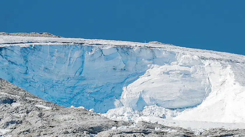 A rescue helicopter flies over the Punta Rocca glacier near Canazei, in the Italian Alps in northern Italy, Wednesday, July 6, 2022, where an avalanche broke loose on Sunday, sending tons of ice, snow, and rocks onto hikers. (AP Photo/Luca Bruno)