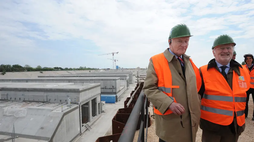 L'ing. Giovanni Mazzacurati ( a sx della foto con occhiali scuri), direttore dei lavori del Consorzio Venezia Nuova, e il sindaco di Venezia Giorgio Orsoni ( a dx della foto) posano dall'alto della conca con i cassoni di alloggiamento in cemento delle paratie mobili, sulla bocca di porto di Cavallino-Treporti, il 28 aprile 2011. ANSA/ANDREA MEROLA