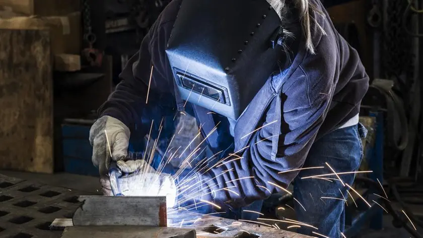 Una donna al lavoro come saldatrice