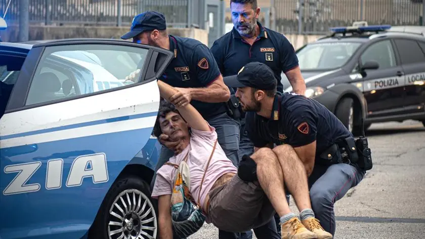 Un attivista di Ultima Generazione viene caricato sulla Volante della polizia