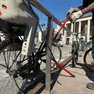 Un addetto della Polizia locale rimuove i telai delle biciclette abbandonate in piazzale stazione