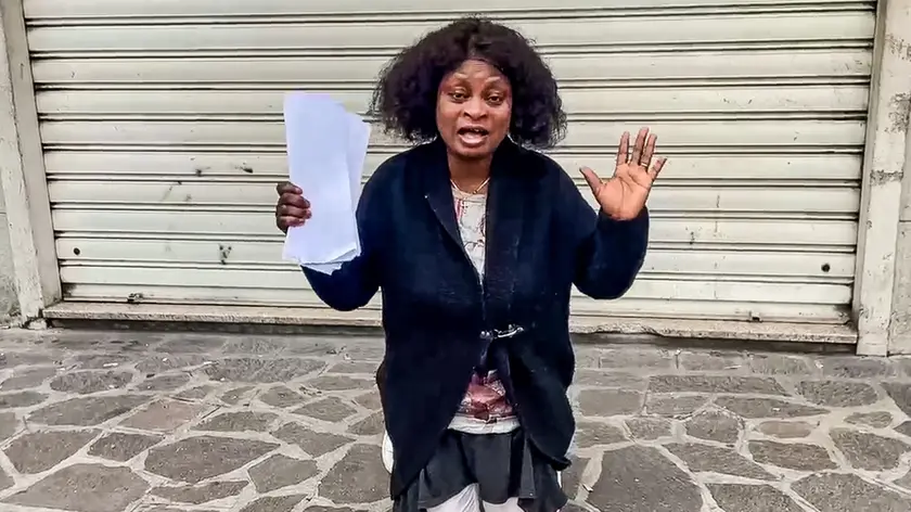 La donna inginocchiata davanti al locale chiuso in zona Arcella