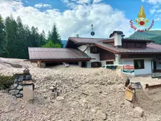 Una casa invasa da sassi e ghiaia della frana a Cancia (foto vigili del fuoco)