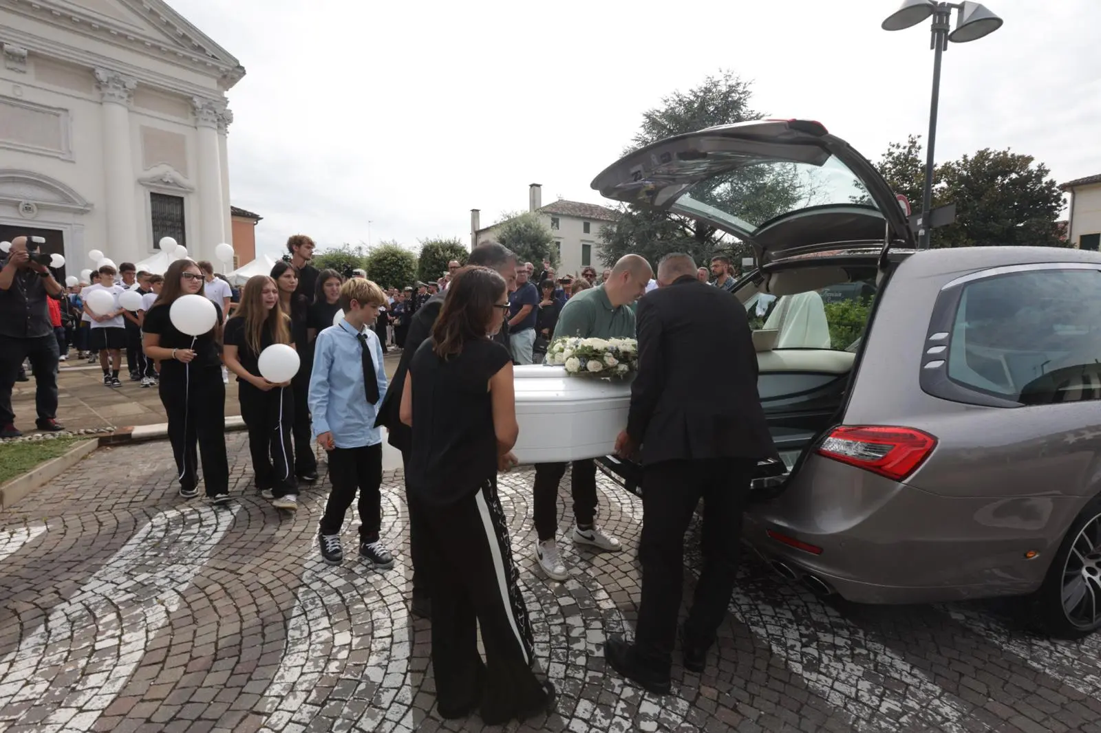 A Roncade è il giorno dell’ultimo saluto a Carlo Panizzo. A centinaia mercoledì mattina, 20 agosto, si sono radunati di fronte al sagrato della chiesa di Roncade in attesa del feretro. Decine di palloncini bianchi sono stati lanciati verso il cielo. Commosso anche il messaggio delle maestre della scuola di San Cipriano. “Hai frequentato la nostra scuola per 3 anni con entusiasmo curiosità e voglia di imparare. La tua gioia era contagiosa”.