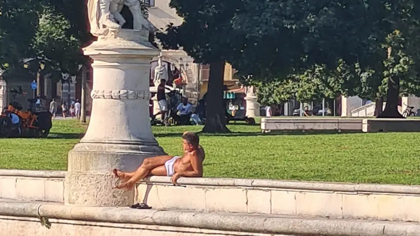 Un giovane in mutande prende il sole in Prato della Valle a Padova
