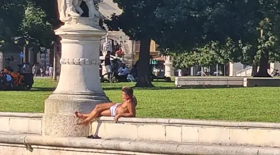 Un giovane in mutande prende il sole in Prato della Valle a Padova