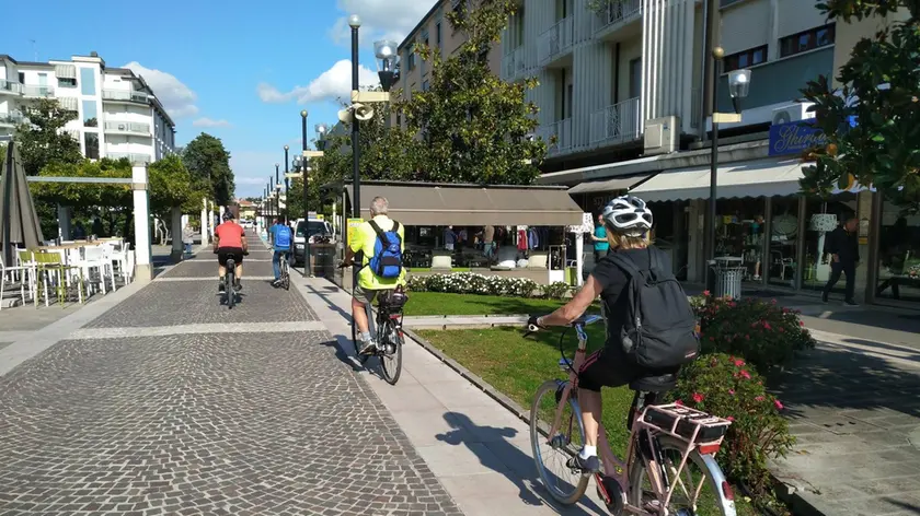 Ciclisti corrono lungo l'isola pedonale