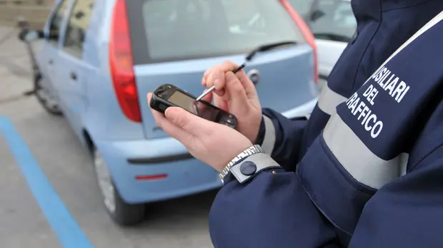 Ausiliare del traffico che compila una contravvenzione