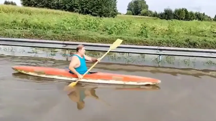 Un uomo in canoa lungo una strada allagata nel Padovano