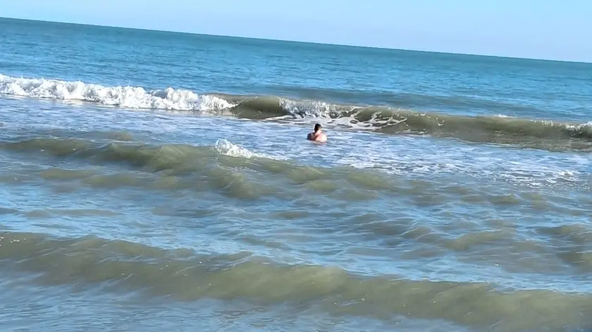 Un turista si concede un bagno a Jesolo a ottobre