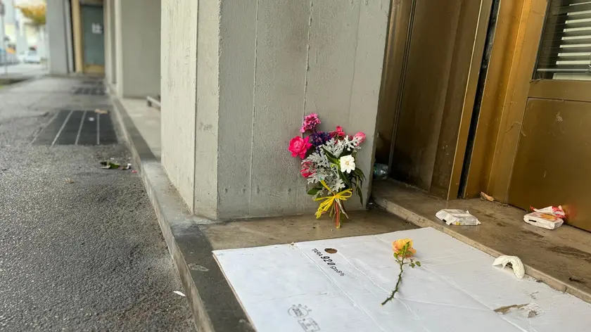 Un mazzo di fiori posato sul luogo in cui è stato trovato il clochard privo di vita
