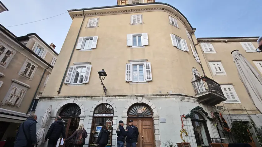 Lo stabile in piazza Marconi a Muggia dove si è consumato il delitto con i poliziotti all'ingressp. Foto Lasorte