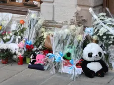 Il piccolo Giovanni Trame e i fiori e peluche lasciati all’esterno dello stabile di piazza Marconi 3 a Muggia, teatro del delitto (Lasorte)