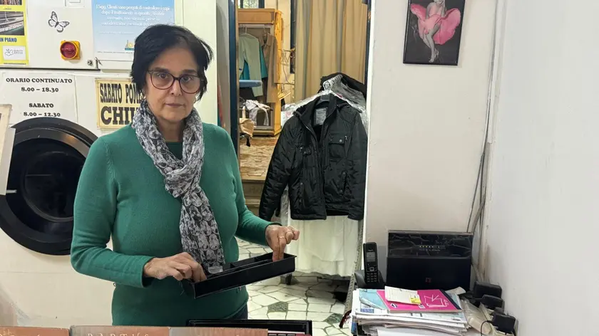 La titolare con la cassa da cui è stato sottratto il denaro