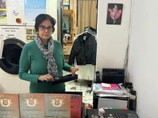 La titolare con la cassa da cui è stato sottratto il denaro