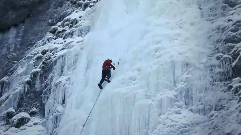 Un alpinista mentre arrampica sul ghiaccio