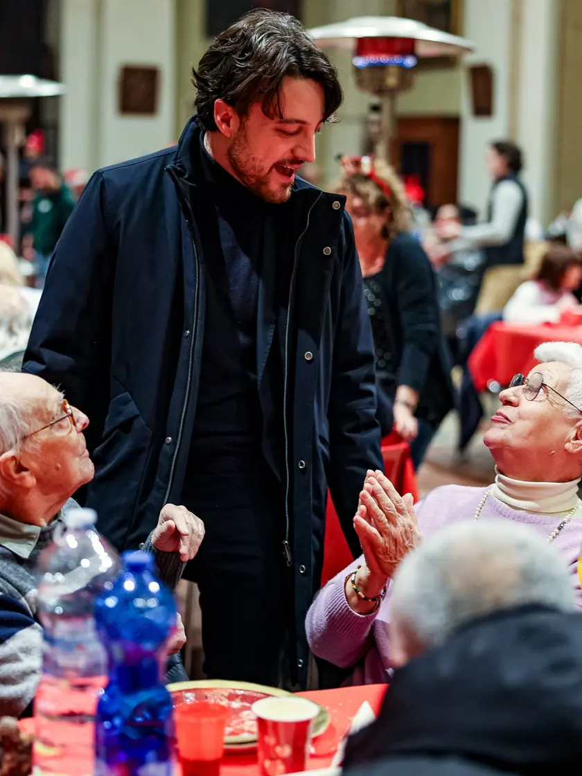 Il presidente della Regione Veneto Alberto Stefani mentre saluta alcuni degli anziani ospiti del pranzo della Comunità di Sant'Egidio