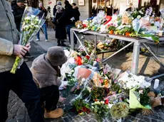 Fiori e candele lasciati fuori dal locale in memoria delle vittime