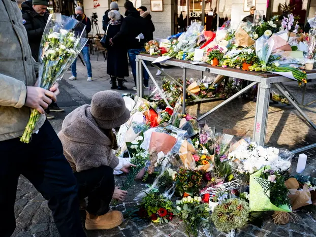 Fiori e candele lasciati fuori dal locale in memoria delle vittime