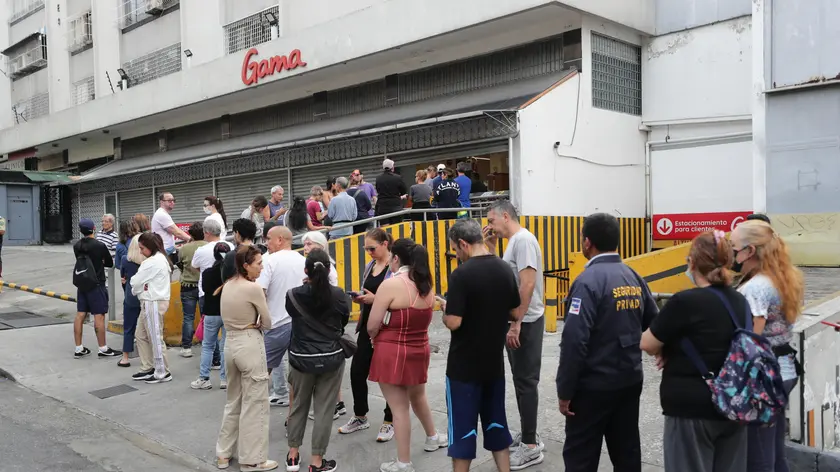 Cittadini in coda davanti a un supermercato a Caracas