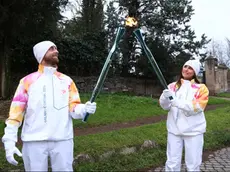 I tedofori Silvio Martinello e Novella Calligaris alimentano la Fiamma Olimpica