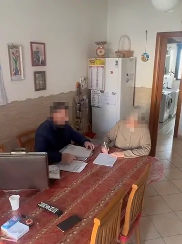 La firma di un contratto da parte di un'anziana nelle immagini diffuse dalla Finanza