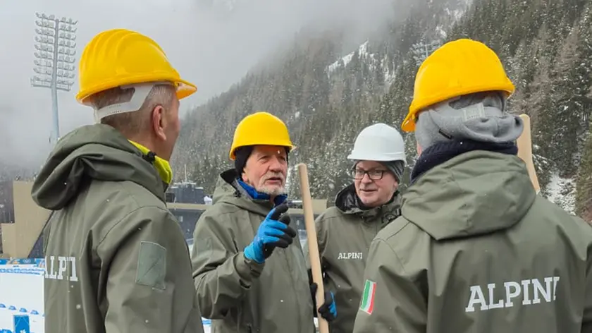 Alpini con le pale sotto la neve, impegnati come volontari nelle aree dolomitiche dei Giochi olimpici