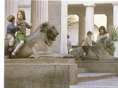 Una vecchia foto del caffè Pedrocchi e i bambini che giocano sui leoni