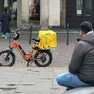 Abdullah in piazza delle Erbe a Padova, seduto sulla fontana. A pochi passi la sua bicicletta