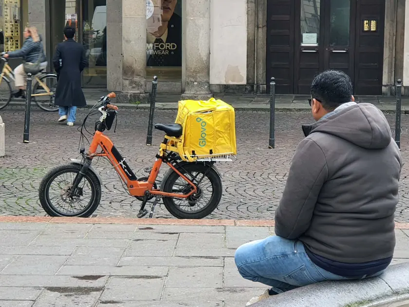 Abdullah in piazza delle Erbe a Padova, seduto sulla fontana. A pochi passi la sua bicicletta