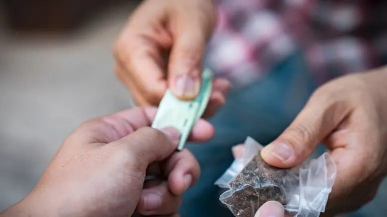 Uno spacciatore consegna l'hashish a un cliente