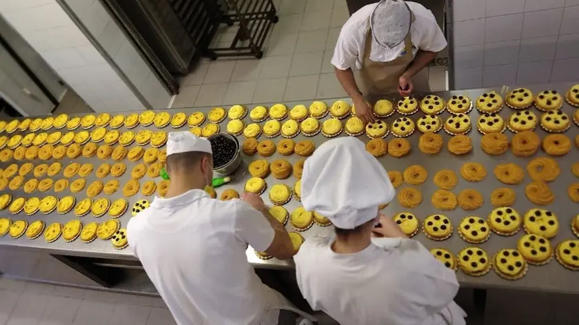 I pasticceri al lavoro per impastare le zeppole