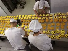 I pasticceri al lavoro per impastare le zeppole