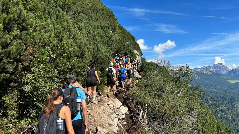 Escursionisti in fila sul sentiero per il lago di Sorapiss
