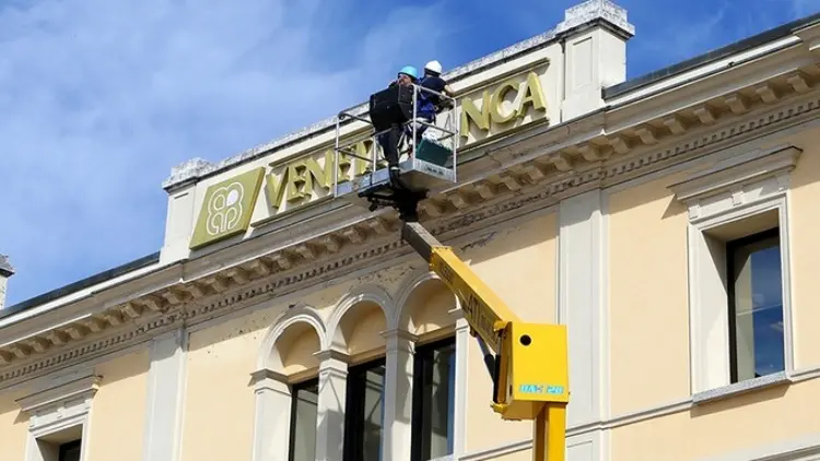 La rimozione dell'insegna Veneto Banca dal cornicione di una sua filiale