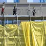 Operai edili al lavoro sulla facciata di uno stabile