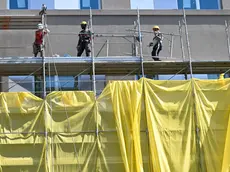 Operai edili al lavoro sulla facciata di uno stabile