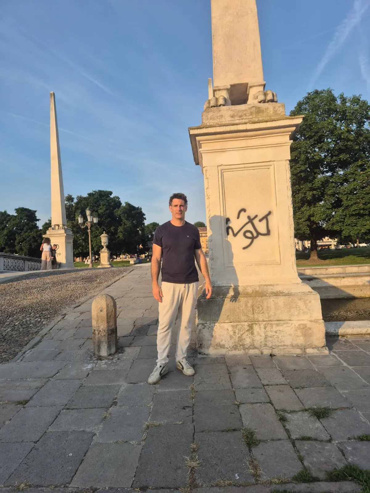 Lorenzo Innocenti, vicesegretario cittadino di Forza Italia di fianco a una colonna imbrattata