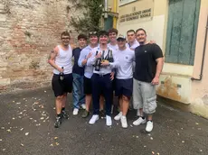 Una foto di gruppo di studenti dopo l'orale della maturità con le bottiglie di Prosecco