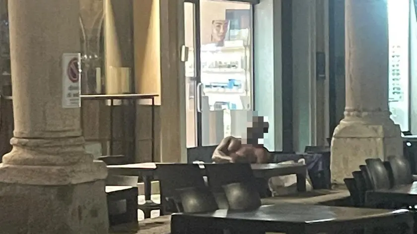 L'uomo mezzonudo addormentato sul plateatico del bar in via Roma a Padova
