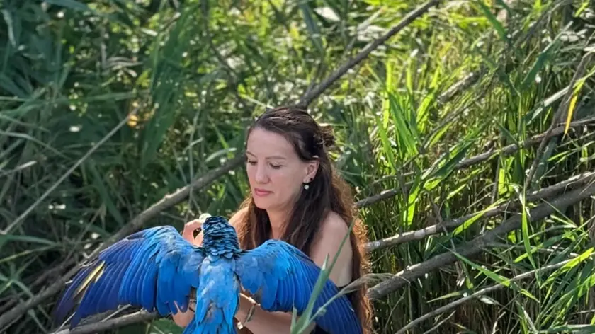 Erika Tamas con il pappagallo Dex salvato lungo il Sile