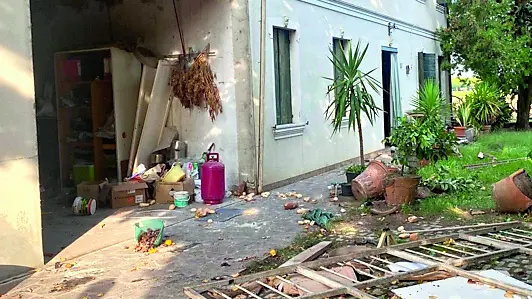 Il portone del garage scaraventato in giardino dopo l'esplosione