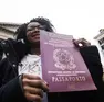 Una donna esibisce un cartello a favore della concessione della cittadinanza