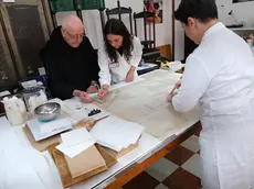 Al lavoro, le mani esperte e i monaci al tavolo