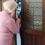 Anziana schiaccia le dita sulla porta di casa a un potenziale truffatore.
