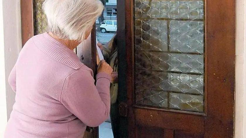 Anziana schiaccia le dita sulla porta di casa a un potenziale truffatore.