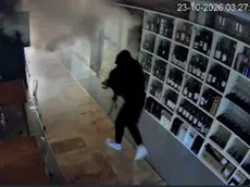 Uno dei ladri in fuga con il bottino nonostante il fumogeno in azione